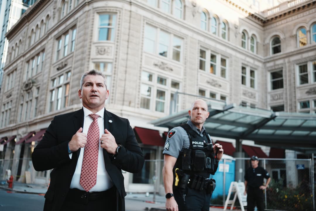 Security personnel in business attire outside urban building