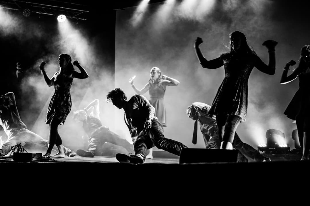 Black and white concert photography with silhouetted performers in stage fog