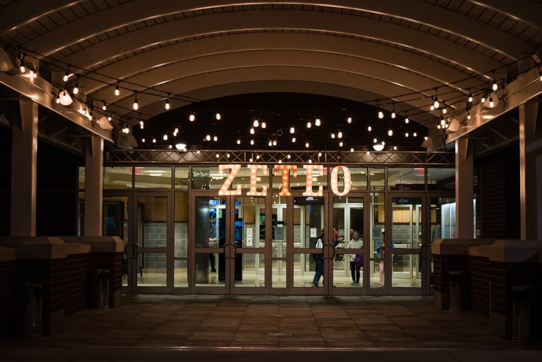 Illuminated Zellerbach Hall entrance at night with string lights