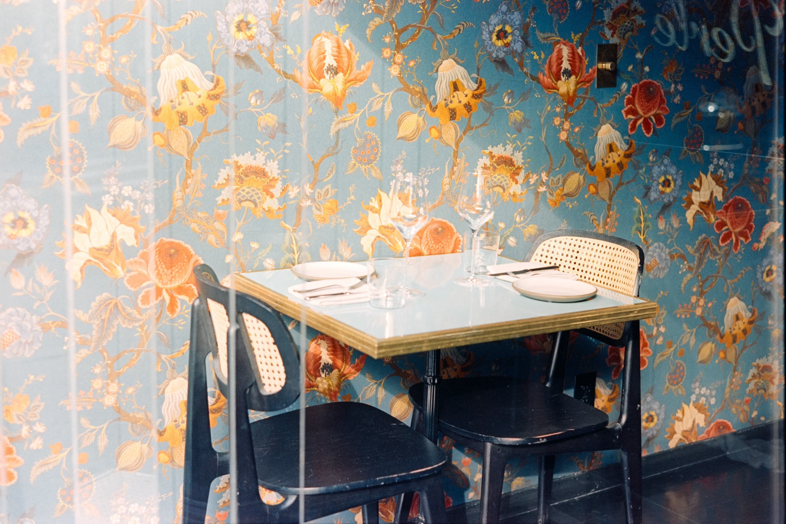 Vintage cafe interior with floral wallpaper and modern furniture setup
